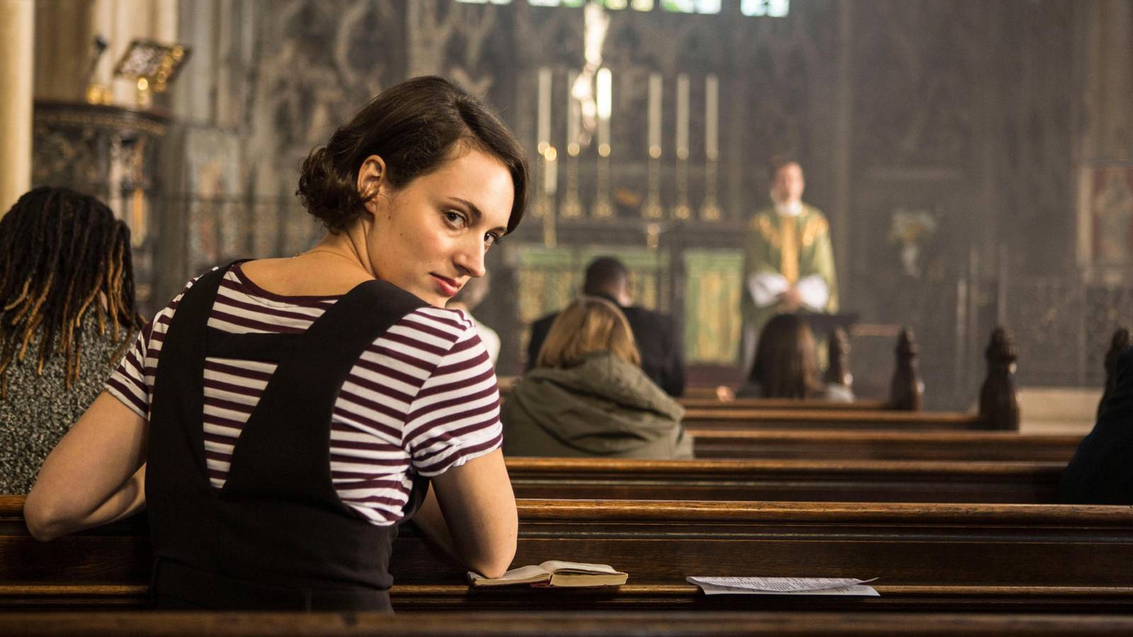 Fleabag looking over her shoulder in a church pew.