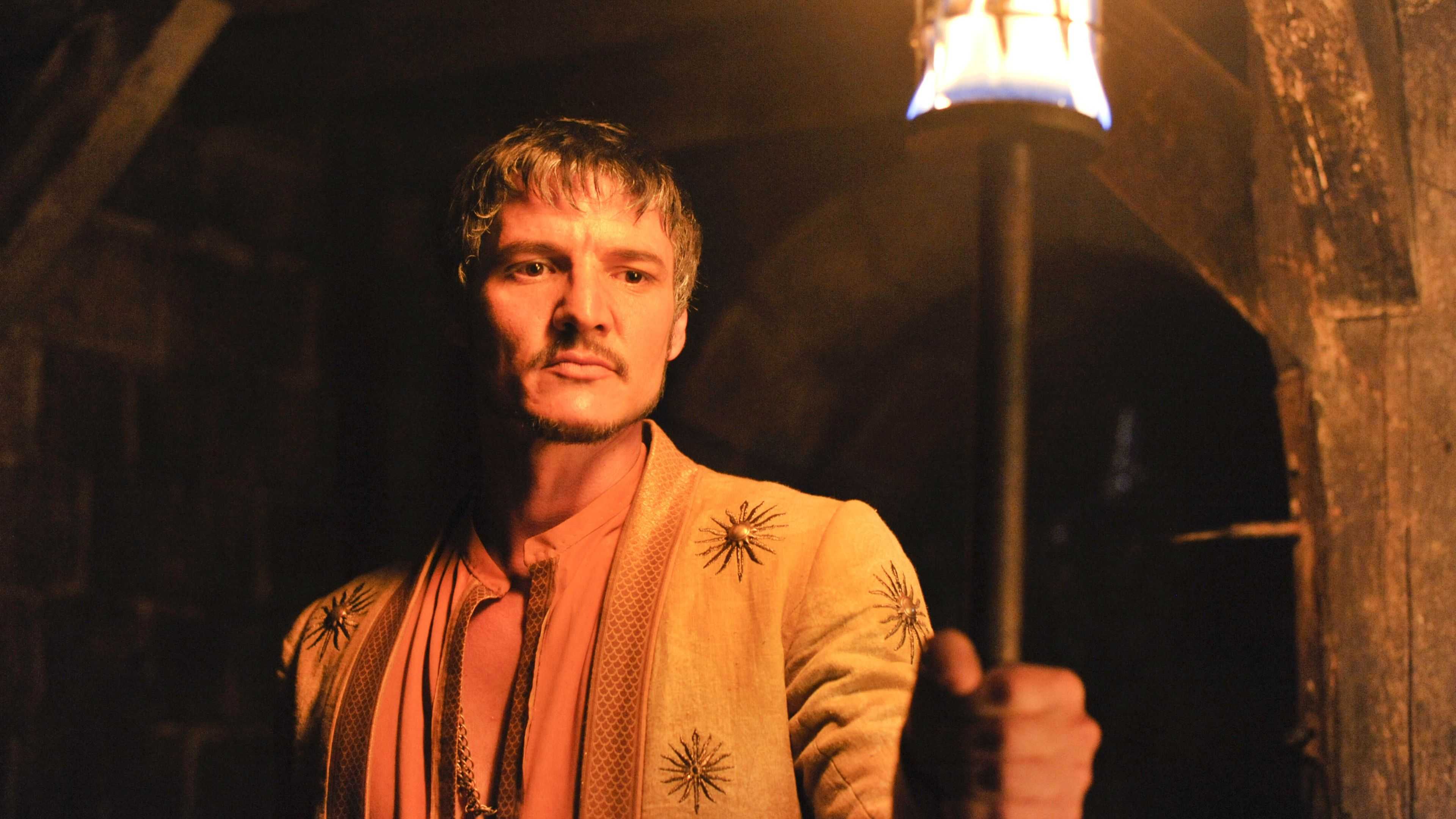 Oberyn Martell (Pedroi Pascal) holding up a torch in Game of Thrones.
