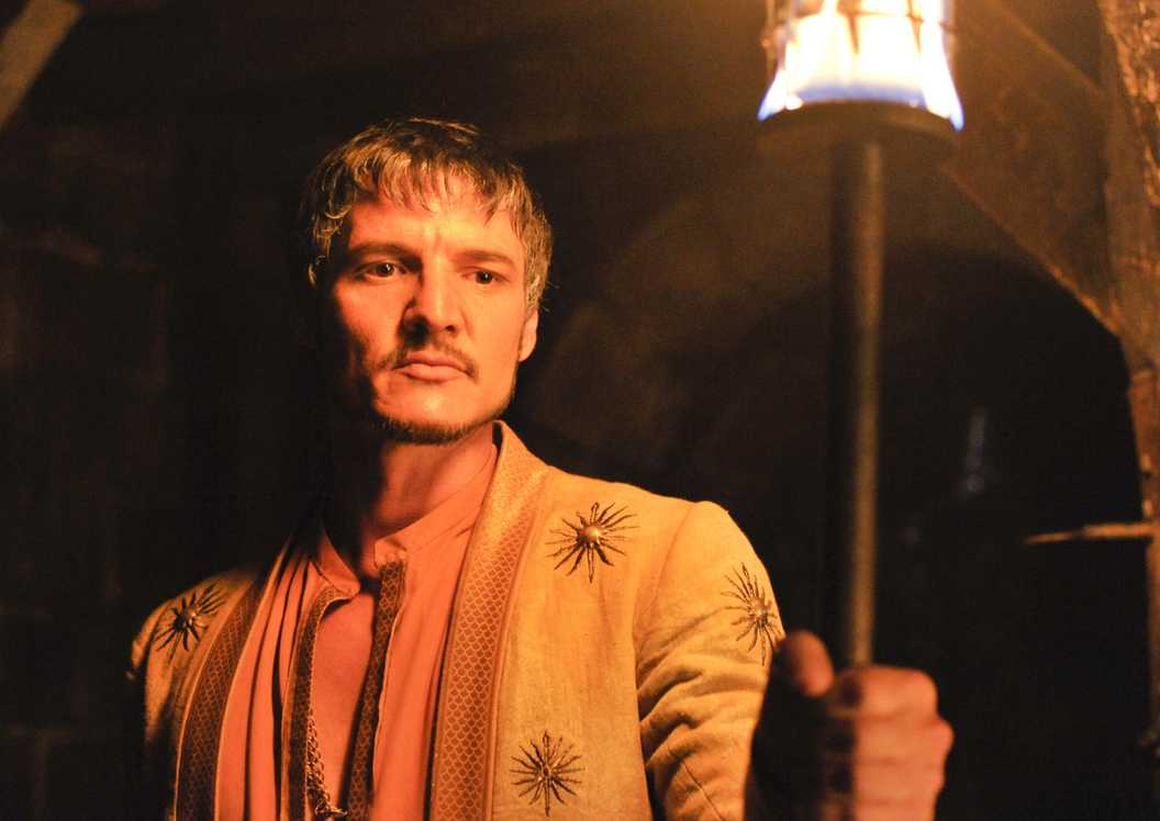 Oberyn Martell (Pedroi Pascal) holding up a torch in Game of Thrones.
