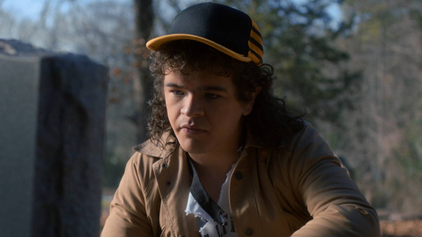 Gaten Matarazzo's Dustin kneels at a grave in Stranger Things season 5