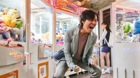 Gi-hun screaming, surrounded by a bunch of arcade machines, in Squid Game