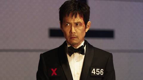 Gi-hun staring angrily in a tuxedo in Squid Game