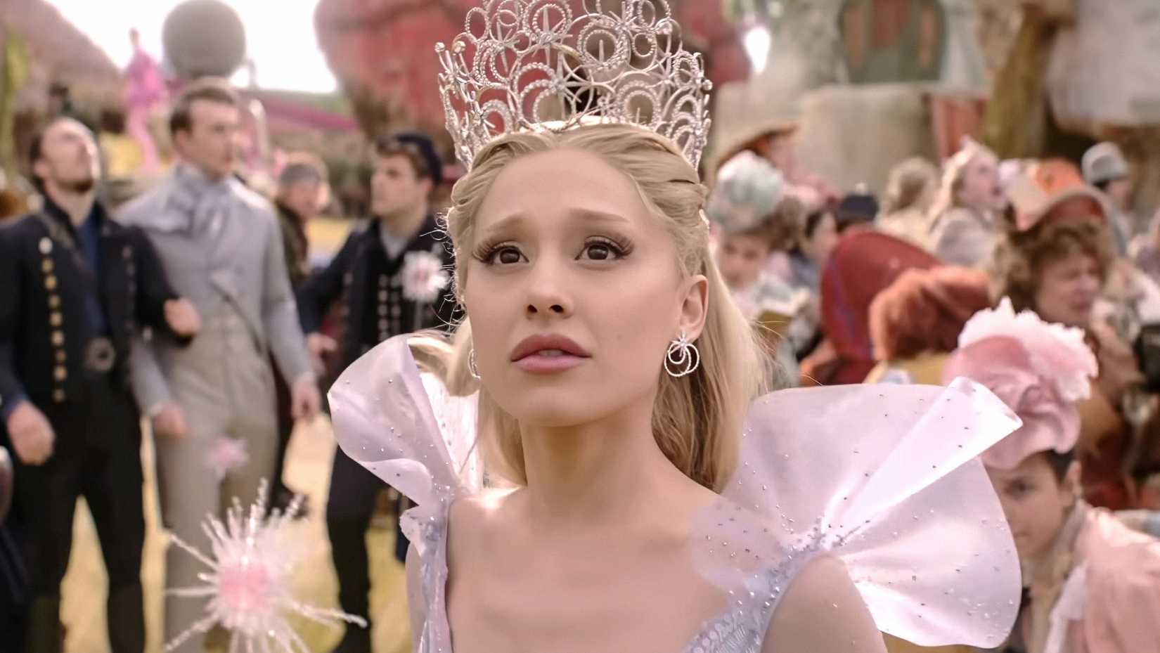 Glinda em seu traje de Glinda A Boa, olhando para cima com uma expressão preocupada em Wicked For Good