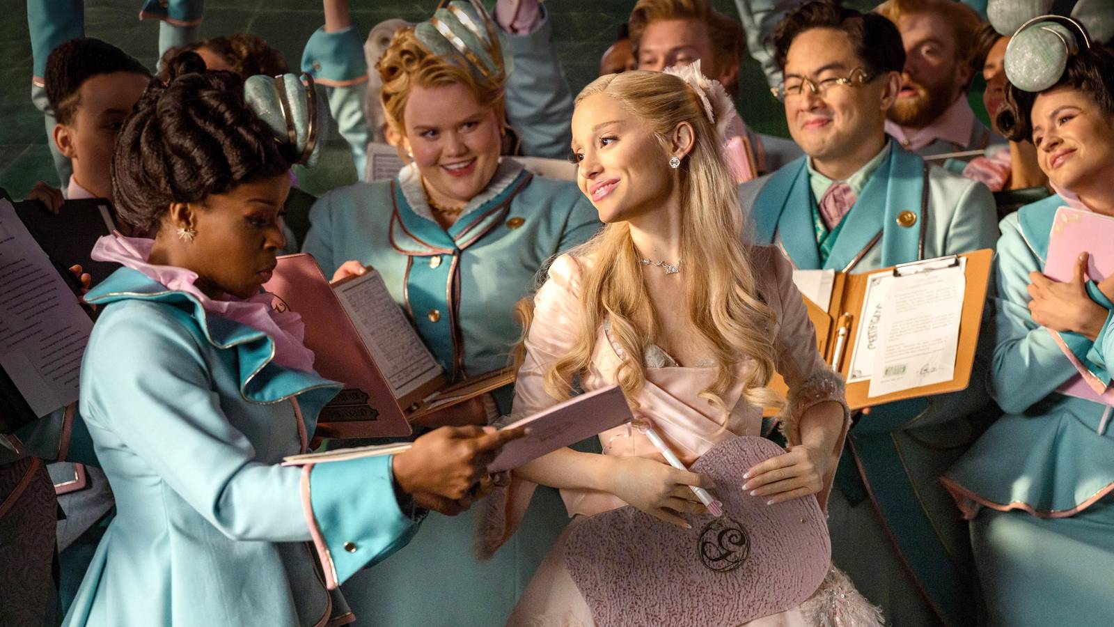 Glinda smiling as she is surrounded by adoring attendants in Wicked For Good