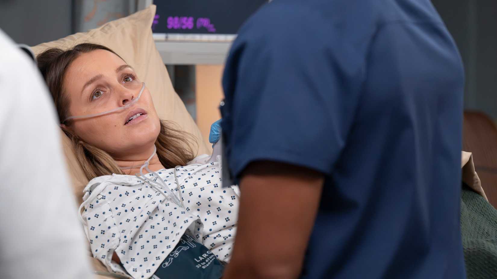 Grey's Anatomy's Jo Wilson with a canula in her nose, looking up at a fellow doctor.