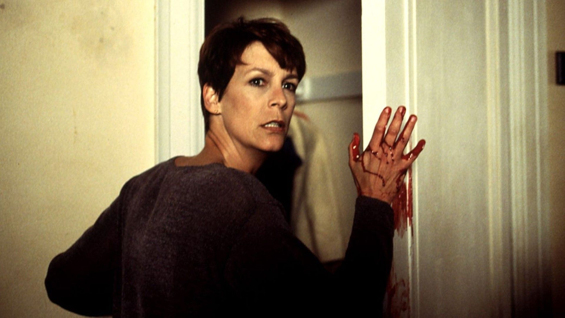 Laurie puts a bloody hand on a doorframe in Halloween H20