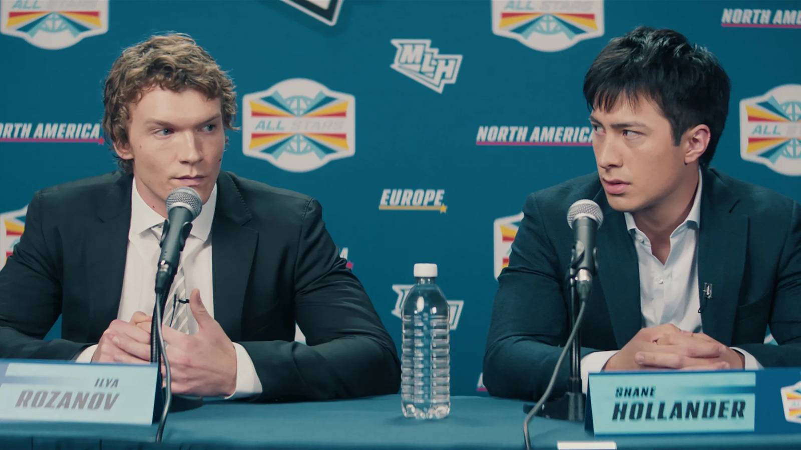 A still from Heated Rivalry featuring Rozanov and Hollander at a press conference.