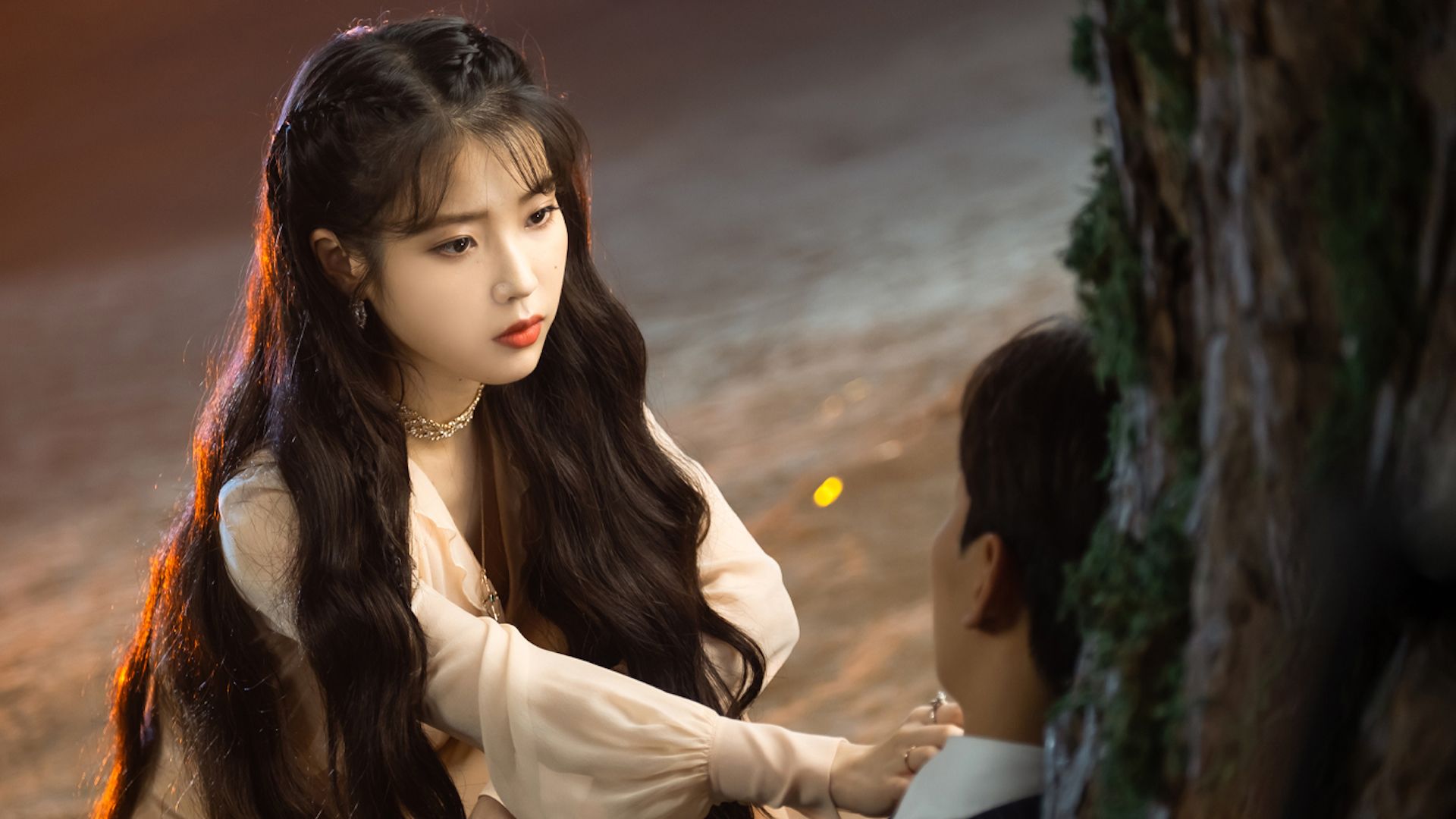 Una donna appoggia la mano sul cuore di un uomo in "Hotel del Luna"