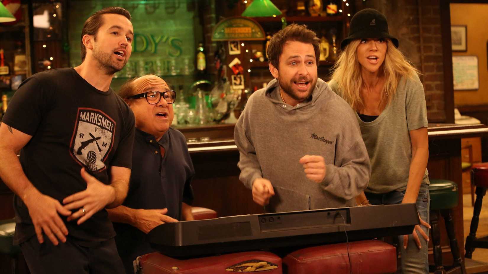 Rob McElhenney, Danny DeVito, Charlie Day e Kaitlin Olson assistindo TV em It's Always Sunny in Philadelphia