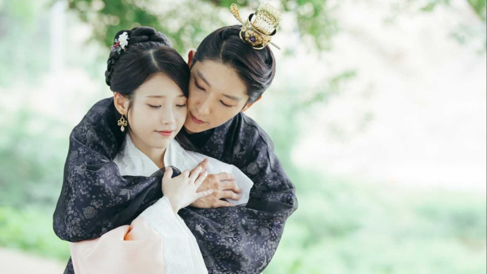 Um homem em trajes da era Goryeo abraçando uma mulher por trás em Moon Lovers: Scarlet Heart Ryeo.