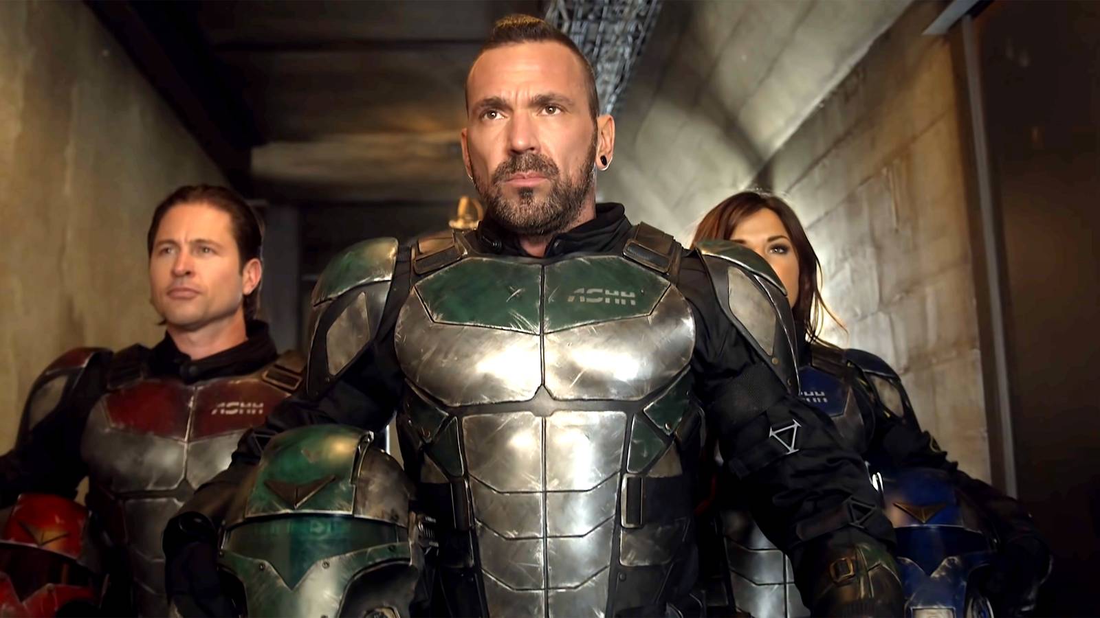 Jason David Frank as Eric walking down a hallway with two people behind him, all in superhero suits, in Legend of the White Dragon