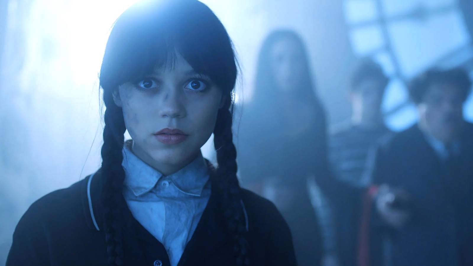 Jenna Ortega como Wednesday luce sorprendida mientras su familia está al fondo en la temporada 2 de Wednesday.