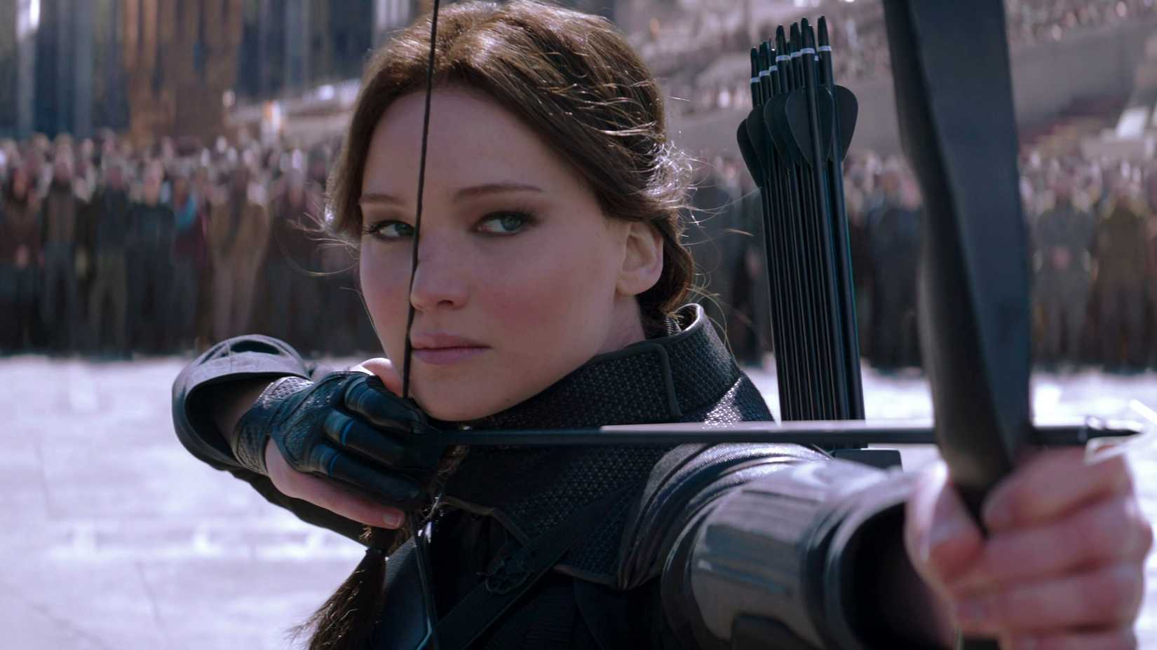 Jennifer Lawrence como Katniss pronta para disparar uma flecha em The Hunger Games: Mockingjay Part 2