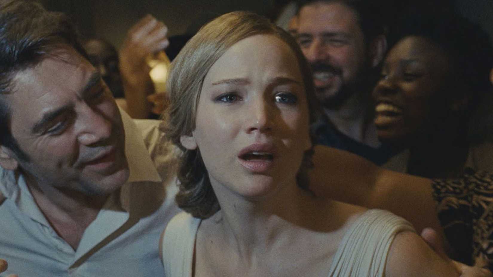 Jennifer Lawrence is being grabbed by several people including Javier Bardem, she looks frightened in the movie Mother