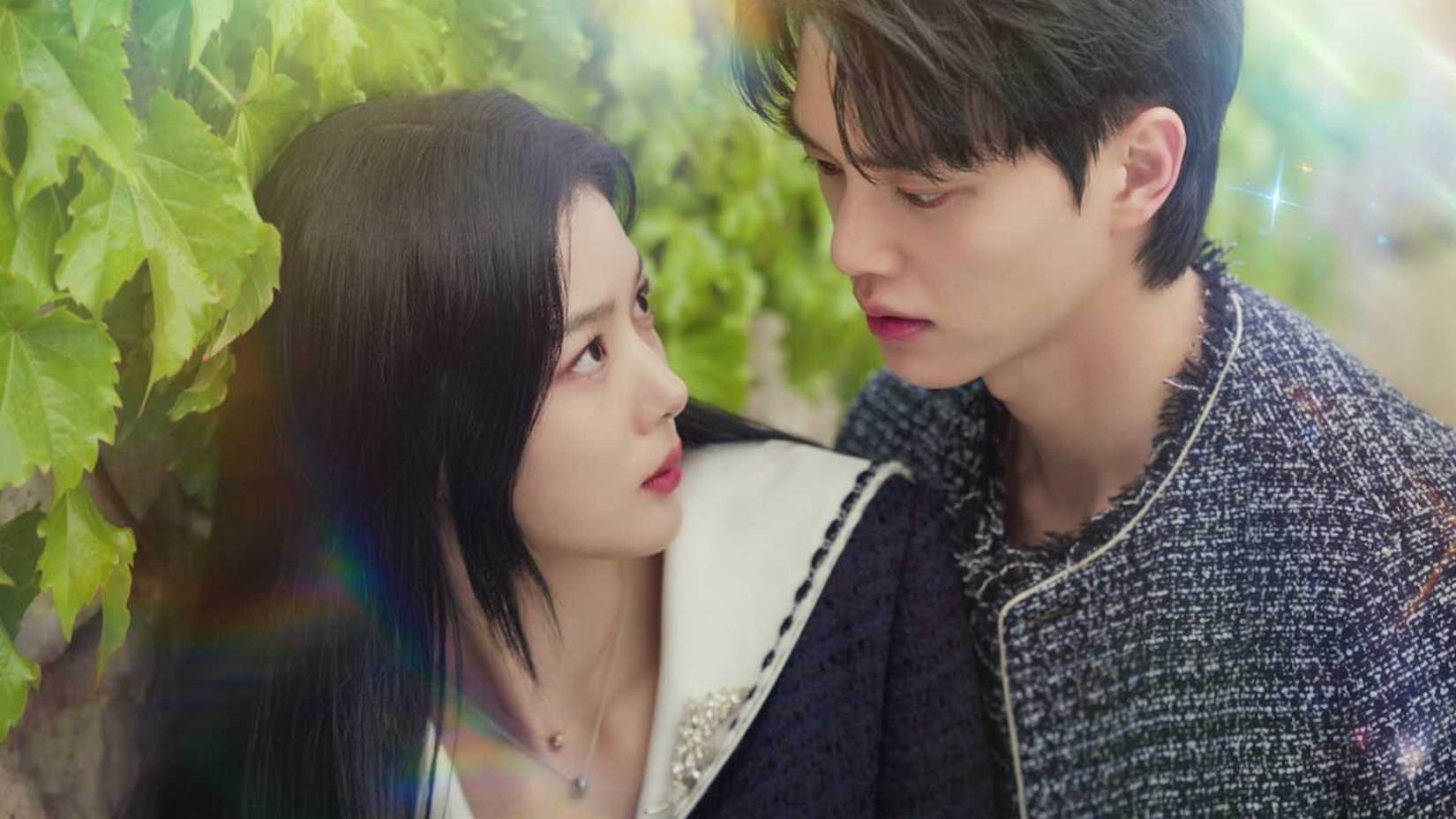 Um homem e uma mulher atrás de um arbusto se olhando em My Demon.