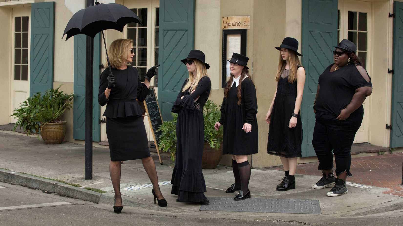 Jessica Lange apontando para um grupo de jovens bruxas em American Horror Story Coven