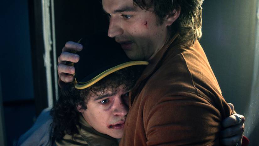Joe Keery's Steve hugging Gaten Matarazzo's Dustin looking distraught in Stranger Things season 5