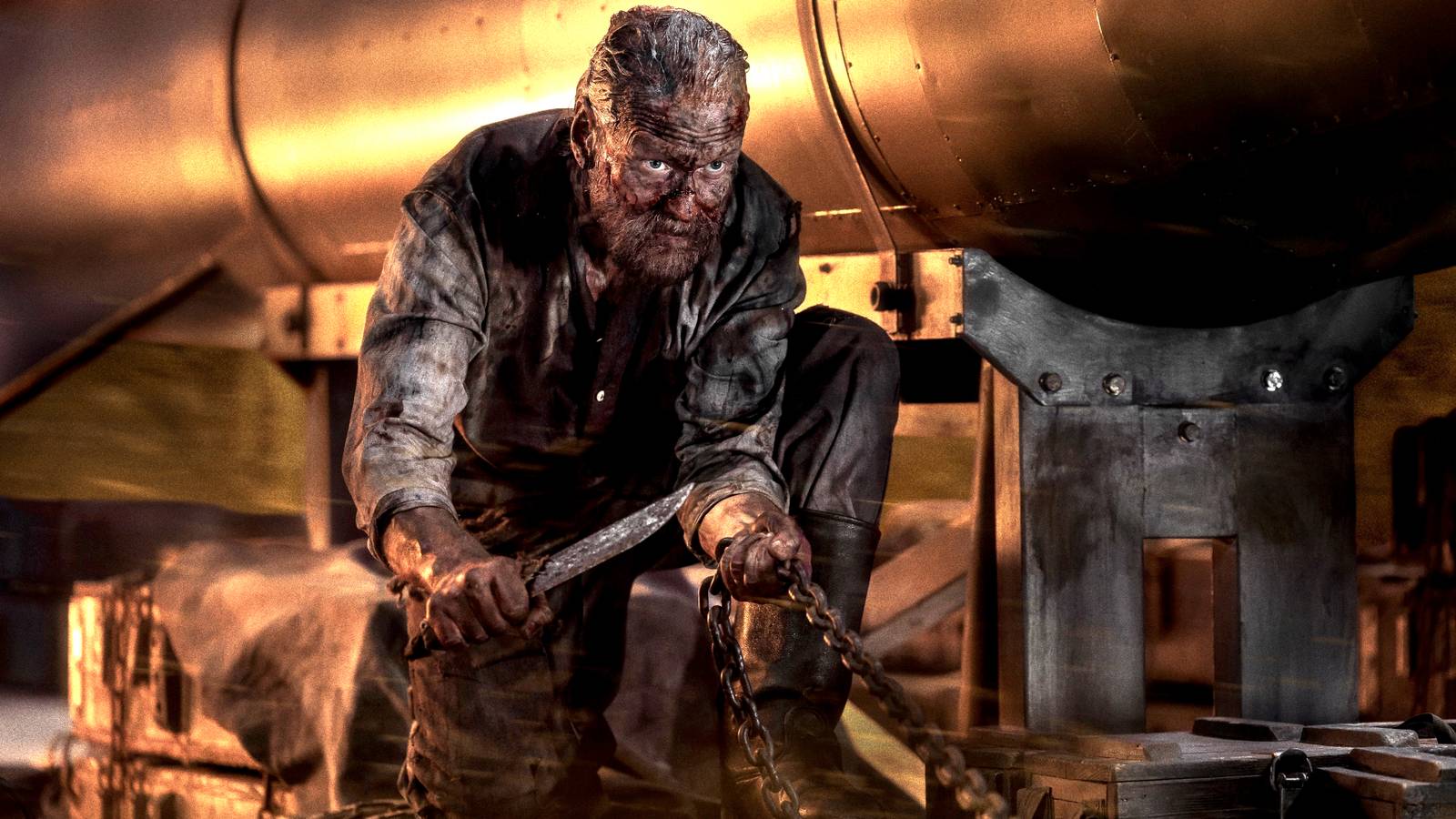 Jorma Tomilla's Aatami on his knees with a knife held toward a chain next to a missile in Sisu: Road to Revenge