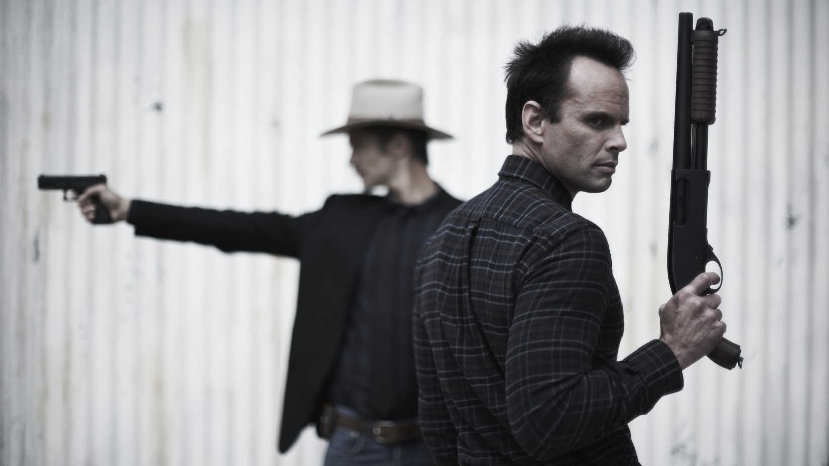 Walton Goggins as Boyd Crowder and Timothy Olyphant as Raylan Givens holding guns in Justified