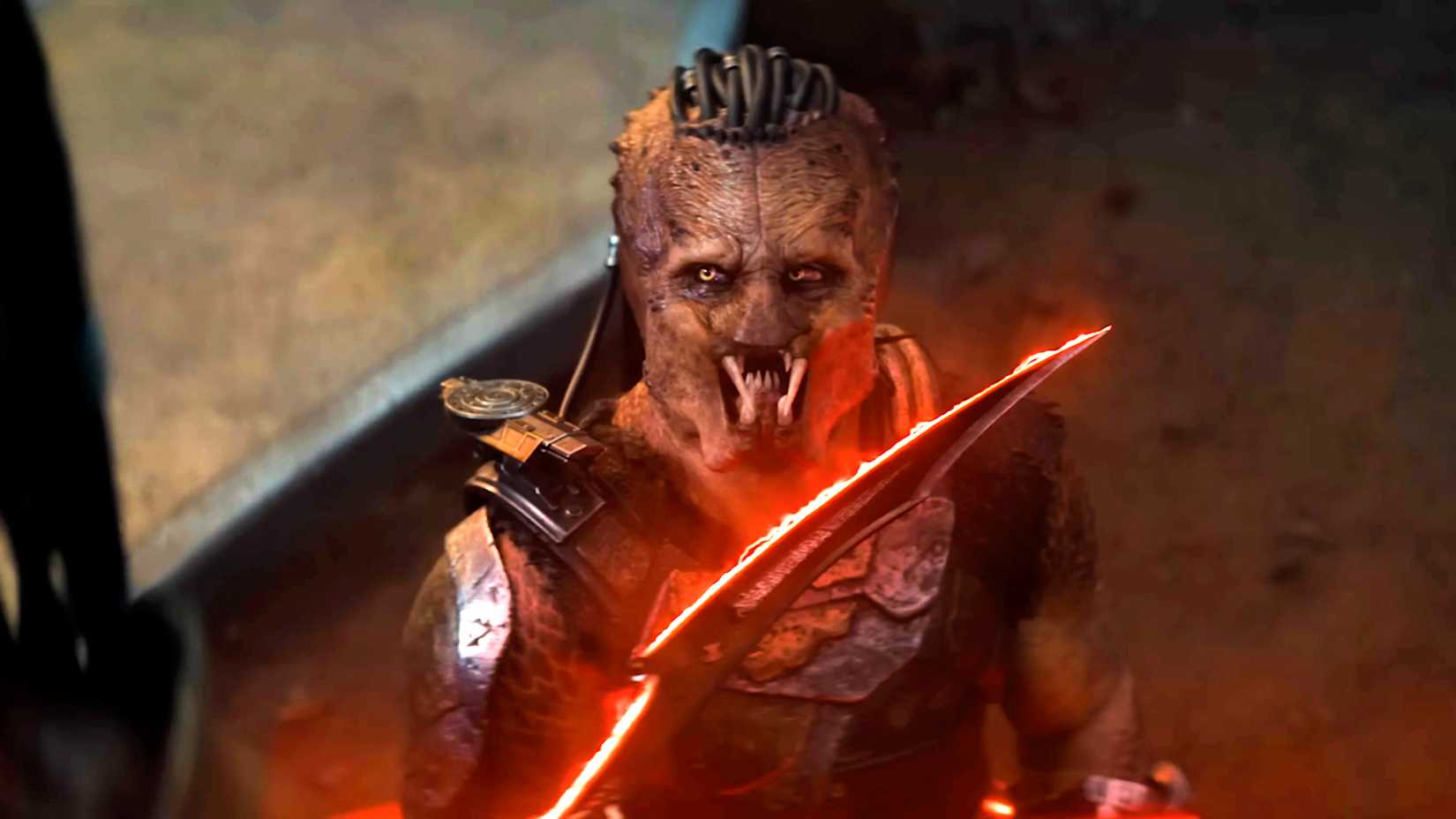 Kwei segurando uma espada para Dek em Predator Badlands