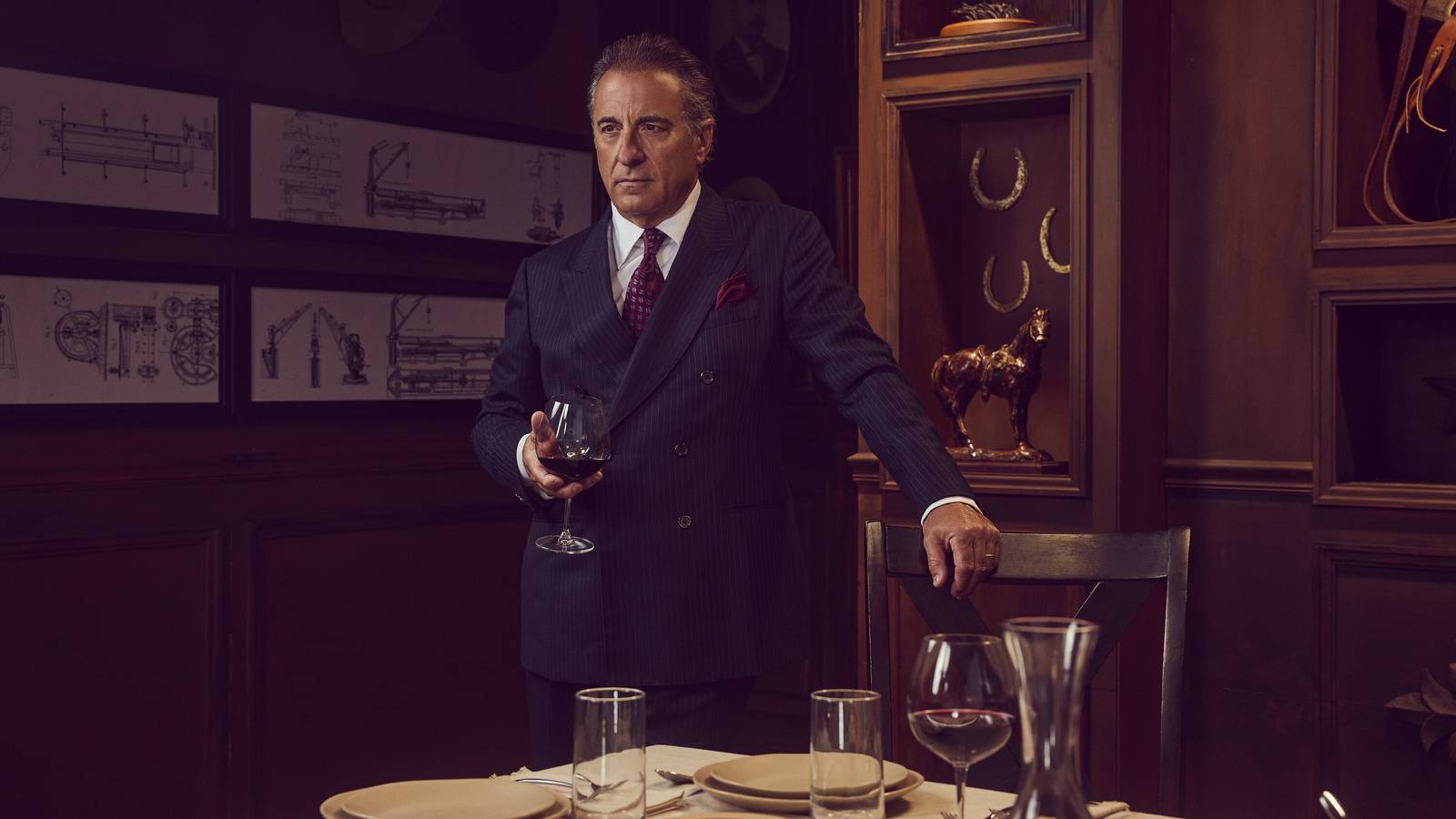 Gallino/Dan Morrell (Andy Garcia) holding a wine glass while standing over a fancy table in Landman season 2