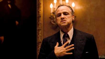 Marlon Brando as Don Corleone touching his chest in The Godfather