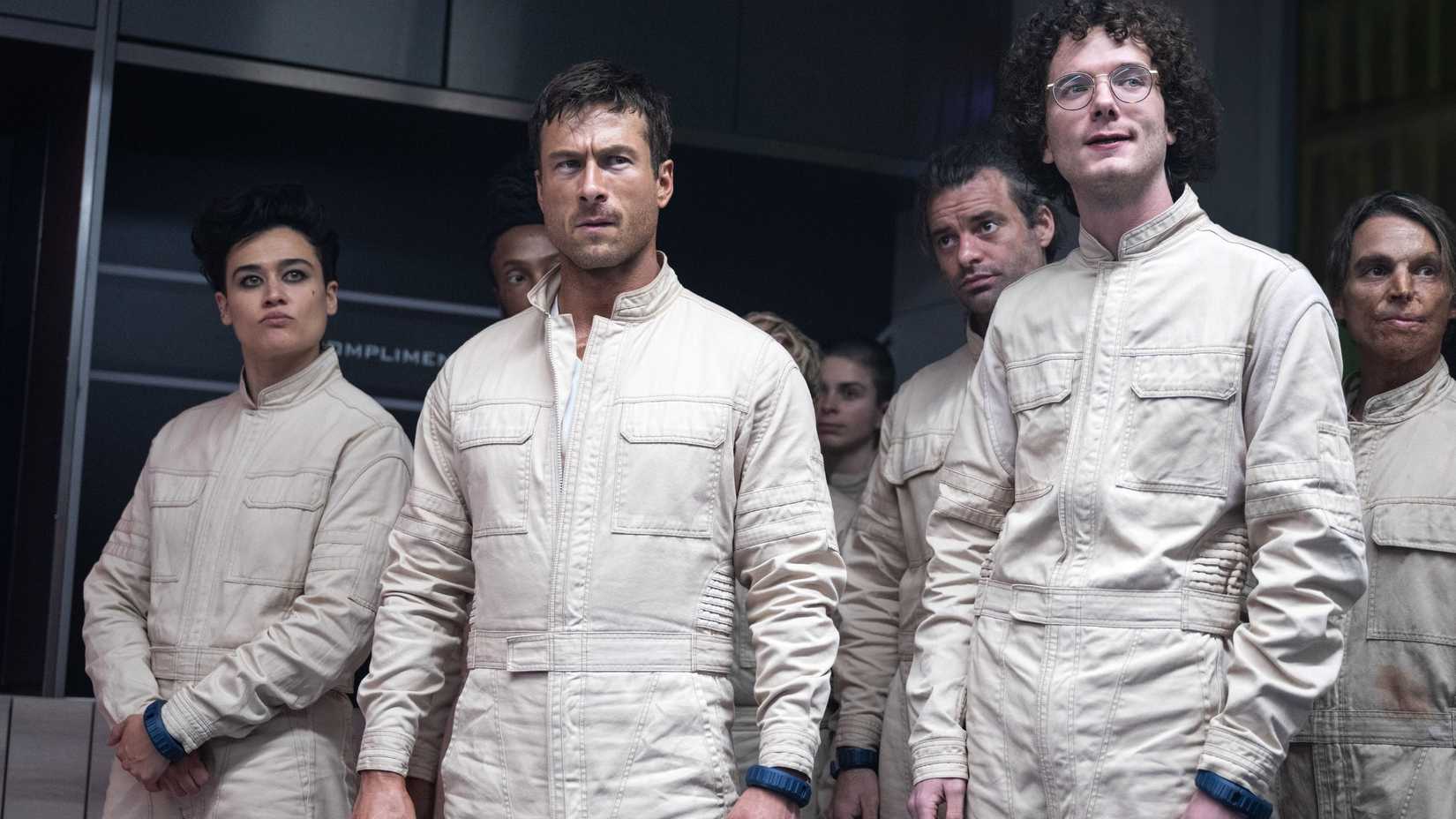 Katy O'Brian (Jenni), Glen Powel (Ben)l, Martin Herlihy (Tim) em uniformes brancos prestes a treinar em The Running Man