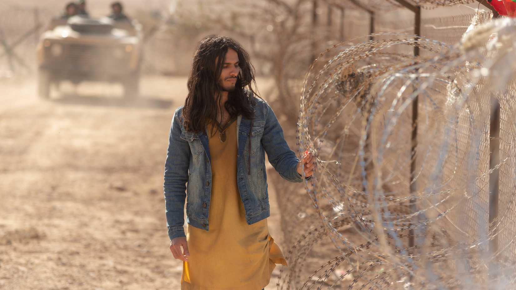 Al-Masih walks beside barbed wire in Messiah