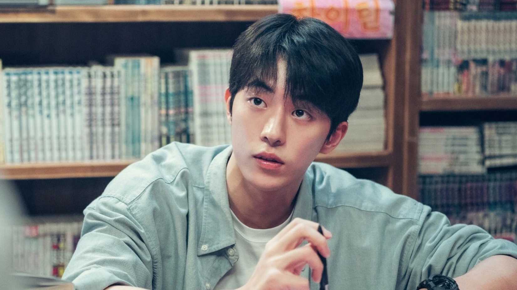 Nam Joo-hyuk cercado por estantes de livros.