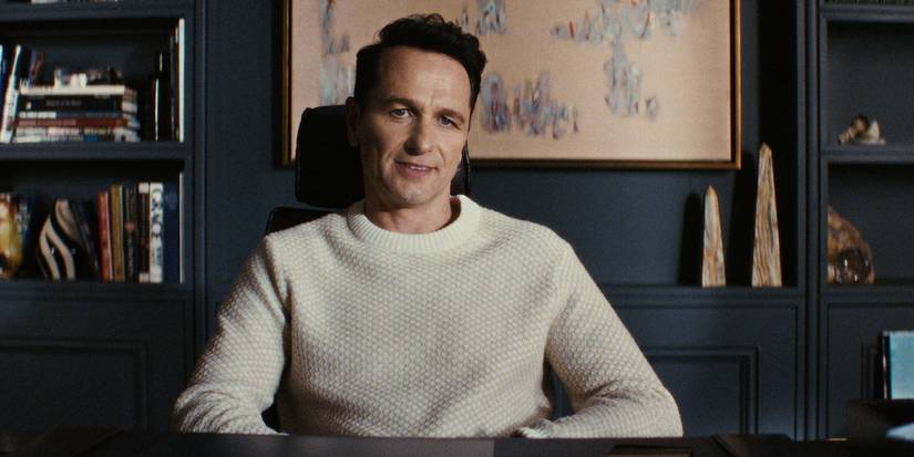 Nile Jarvis sits at a desk smiling in The Beast In Me