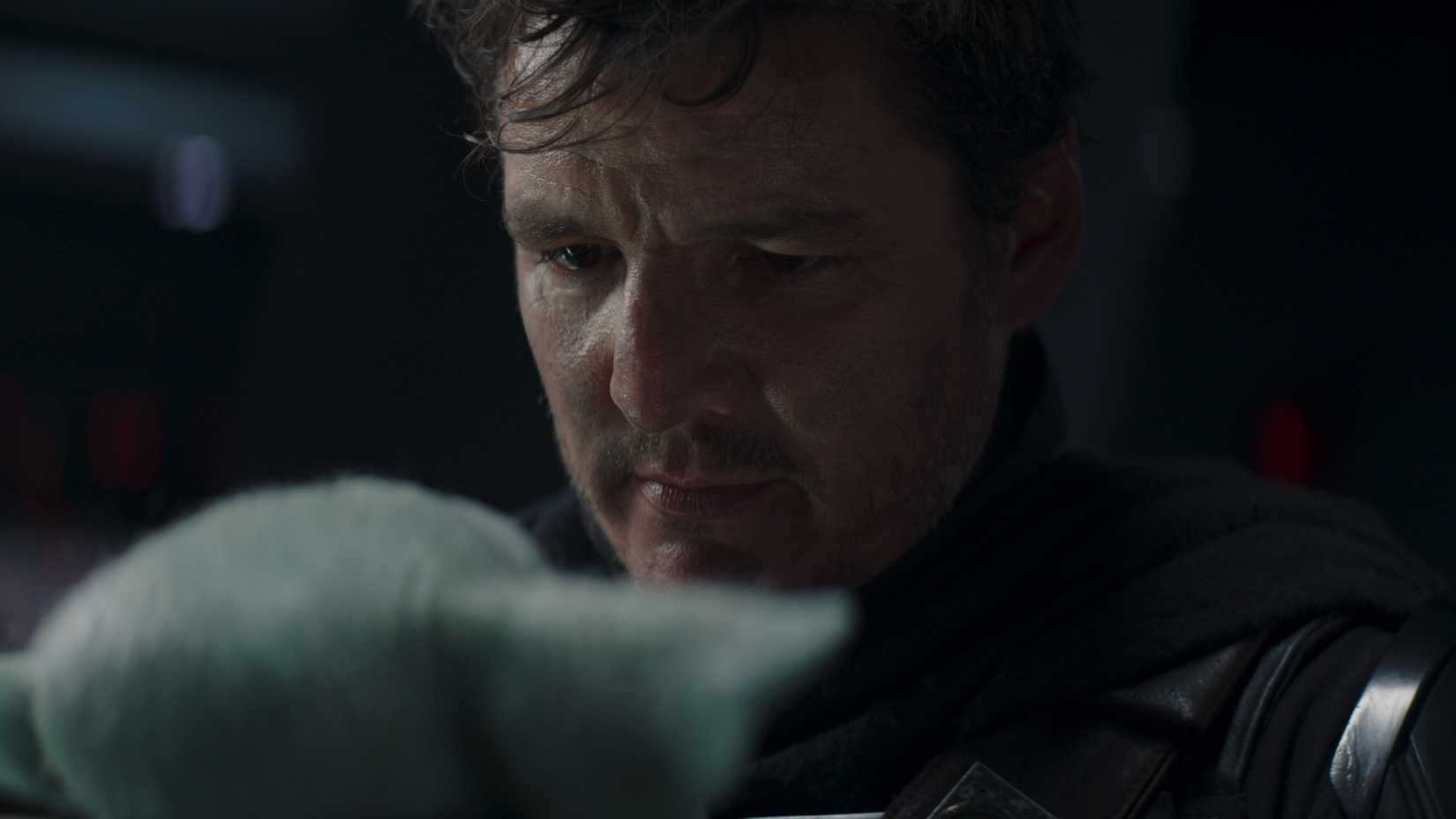 Pedro Pascal chorando como Din Djarin segurando Grogu no final da 2ª temporada de The Mandalorian