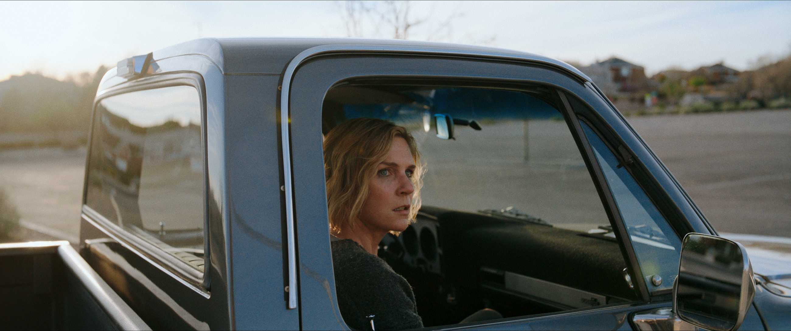 Carol looks out the window of a truck in Pluribus.