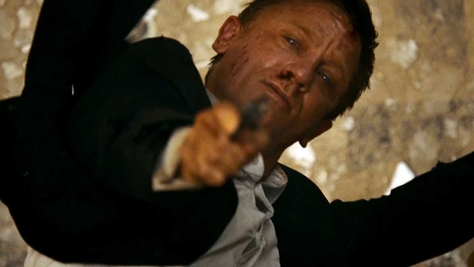 Bond aponta sua arma pendurado em um telhado em 007 - Quantum of Solace