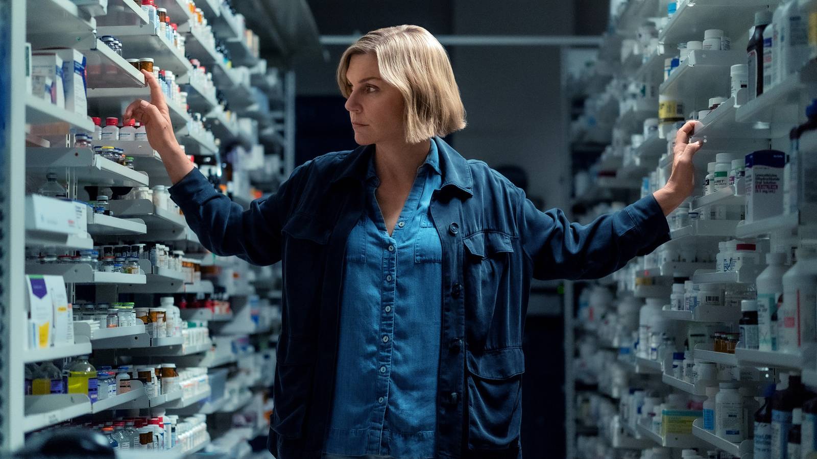 Rhea Seehorn as Carol looking through medical supplies in a hospital in Pluribus episode 4