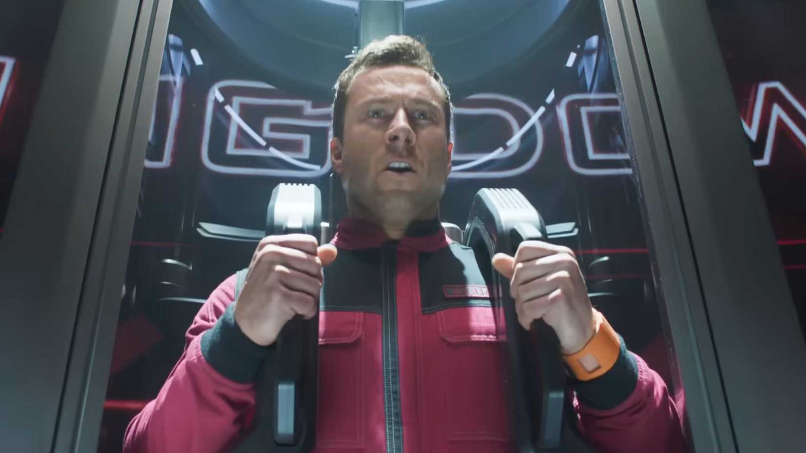 Richards making a face as he prepares to be launched down a tube in The Running Man