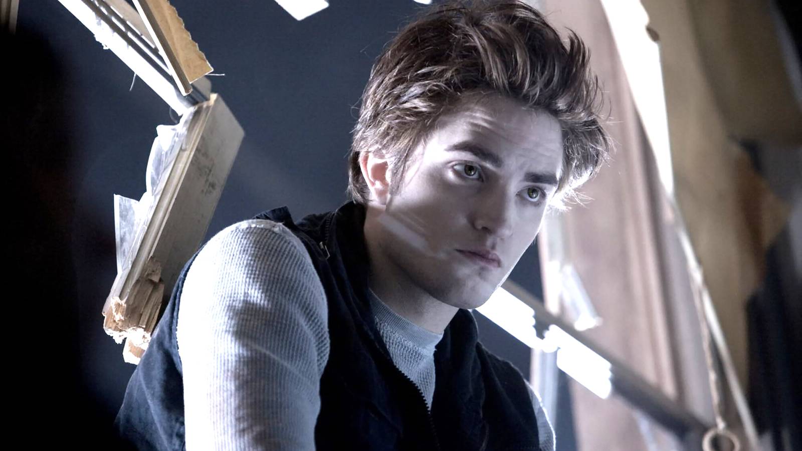 Robert Pattinson's Edward looking intense sitting in a broken window in Twilight