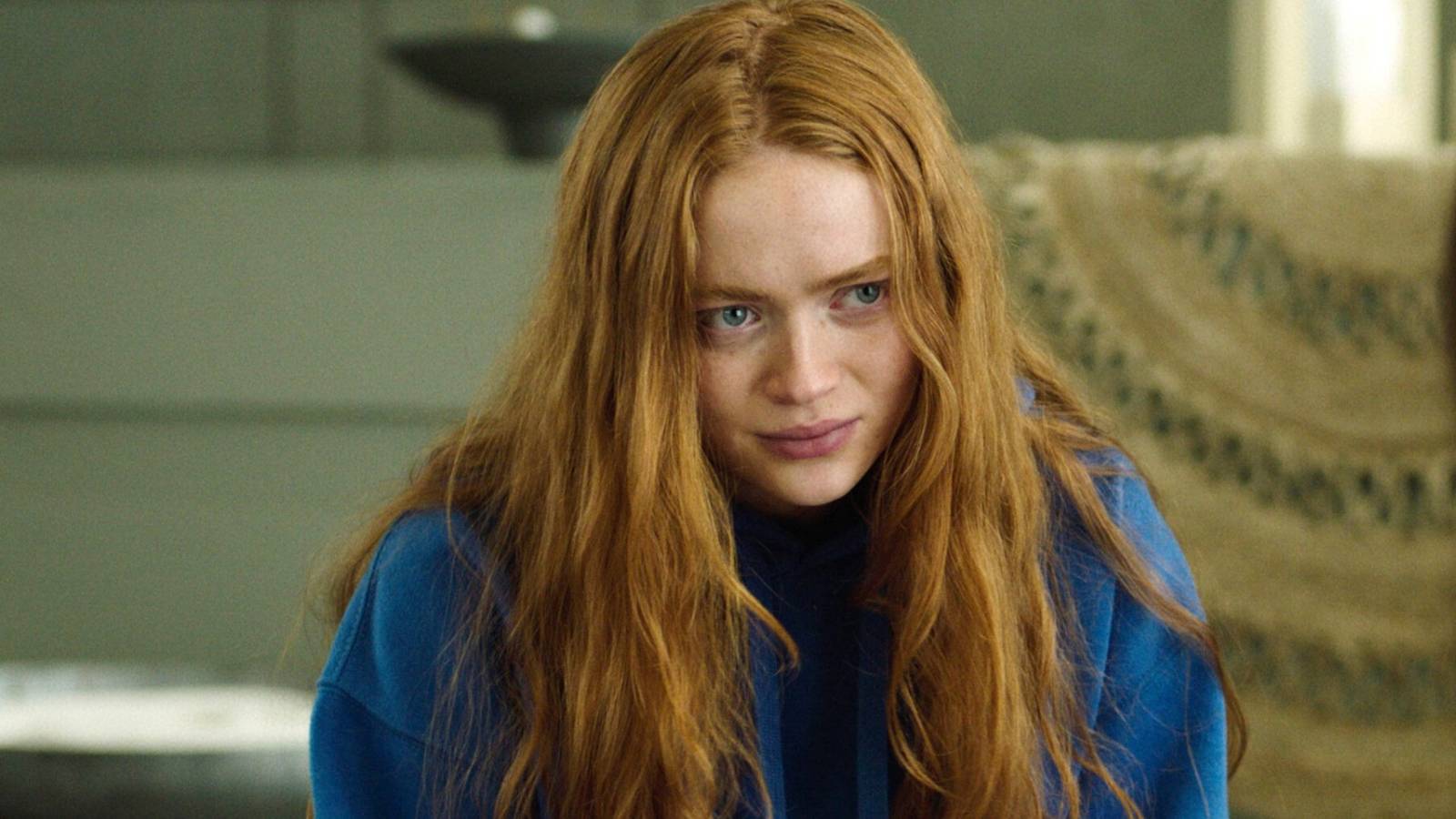Sadie Sink in a blue hoodie looking at someone in A Sacrifice