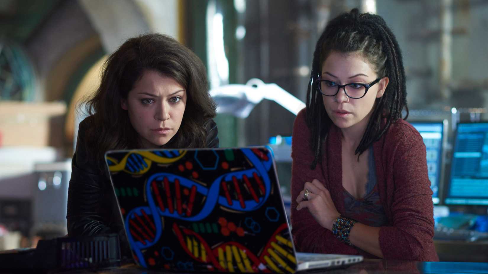 Sarah and Cosima (both Tatiana Maslany) examining Cosima's computer in Orphan Black season 4