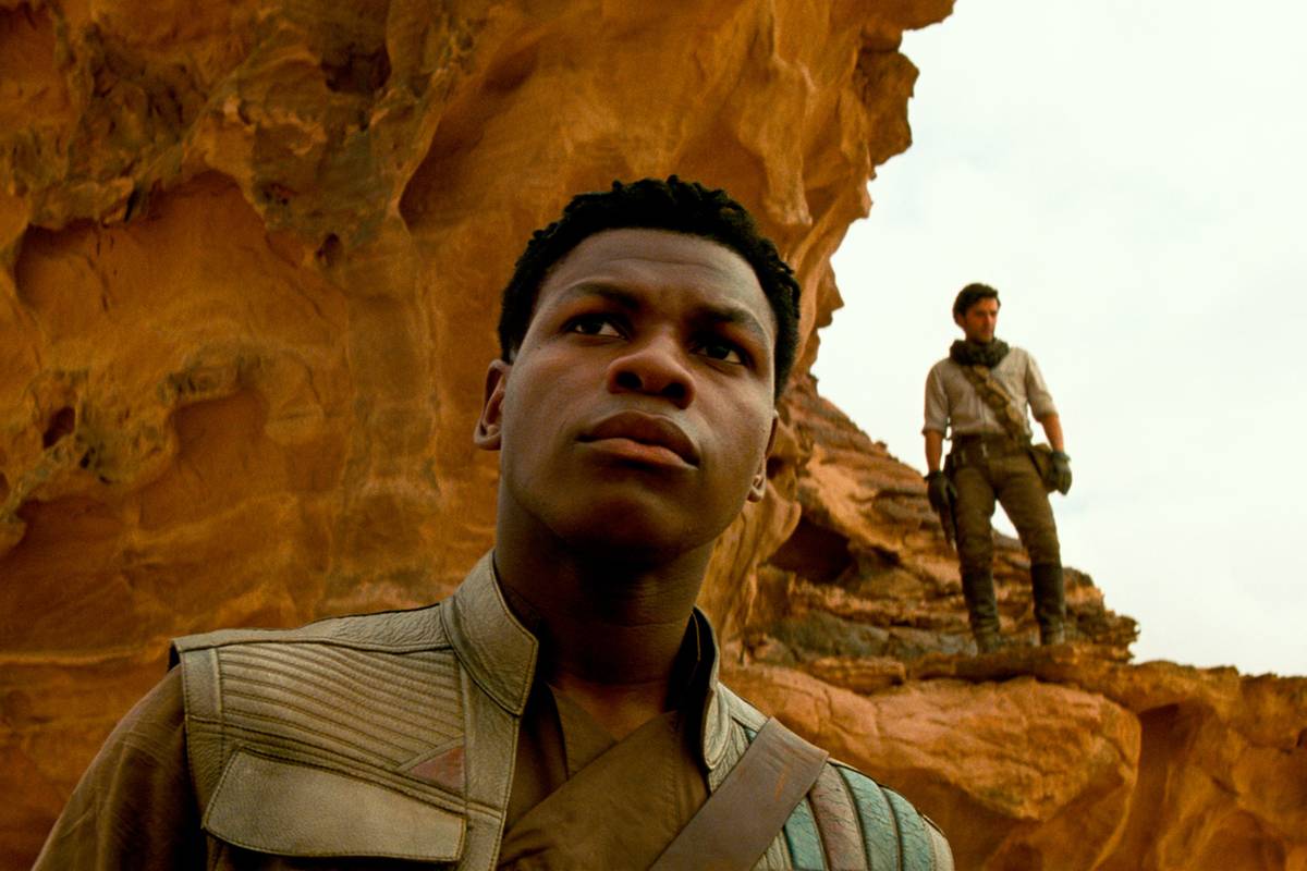 John Boyega as Jedi Finn wielding a blue lightsaber