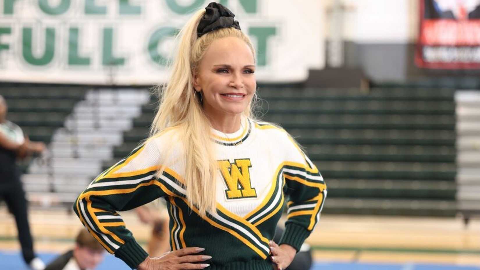 Kristin Chenoweth como Tammy Istiny em Stumble, em pé na academia.