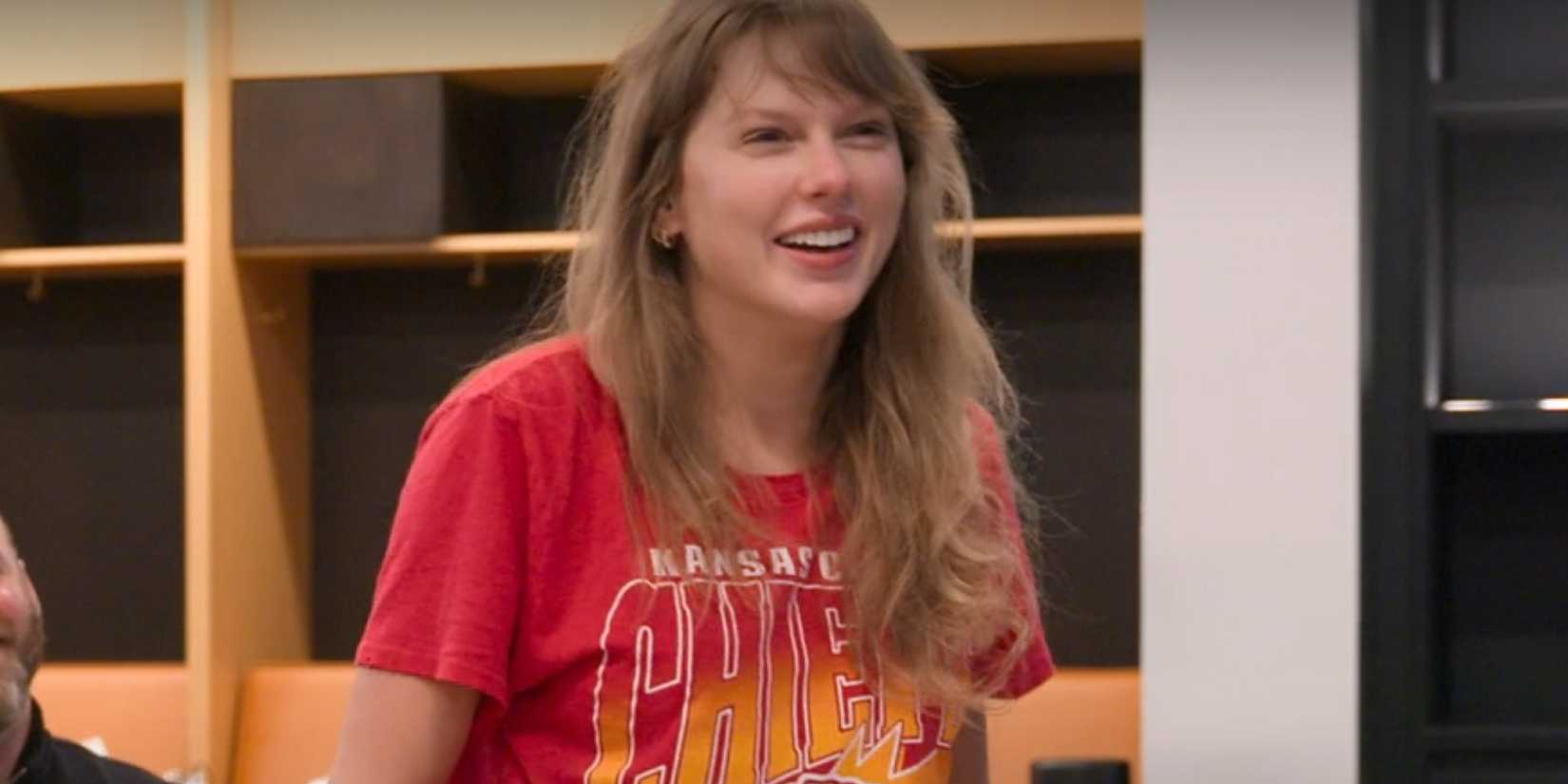 Taylor Swift sorrindo e usando uma camisa do Chiefs no trailer de The End of An Era.