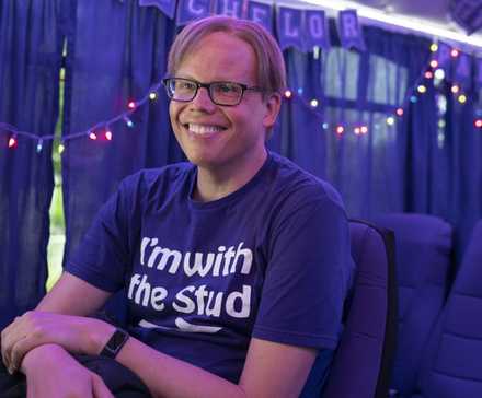 Джоэл (Джефф Хиллер) улыбается на автобусе для холостяков в Somebody Somewhere.