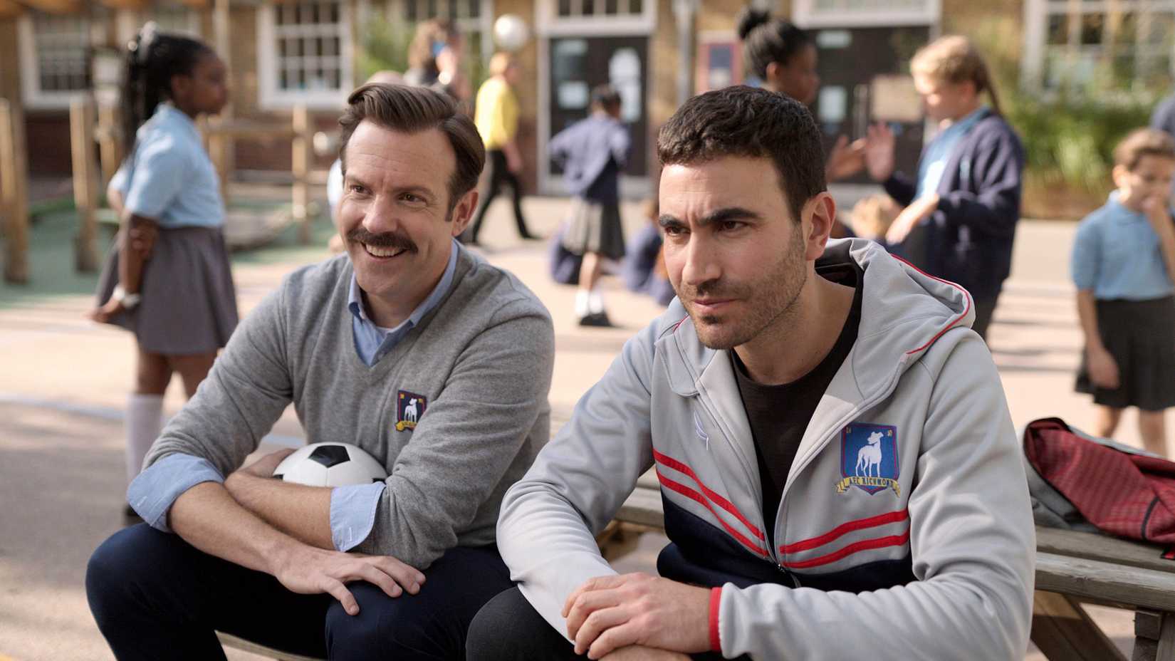 Ted Lasso and Roy Kent sitting together and smiling in Ted Lasso season 3