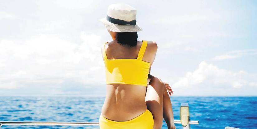 The book cover of The Five-Star Weekend shows a woman sits on a boat looking out at the water