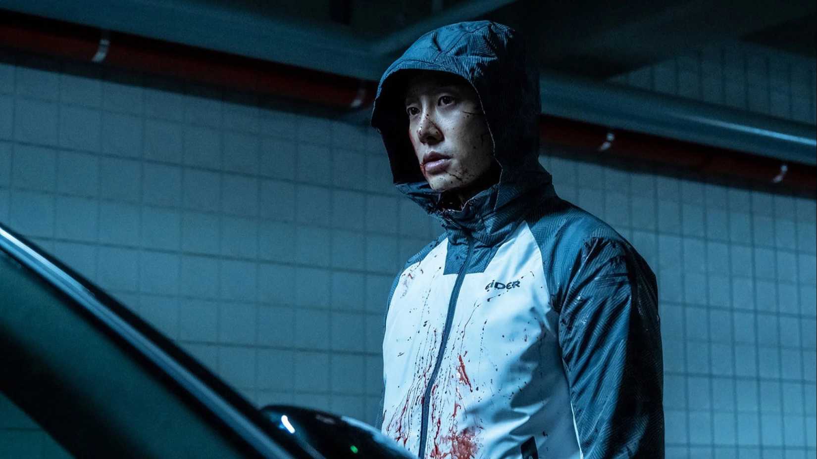 Um homem com o capuz levantado, coberto de sangue, no K-drama The King of Pigs.