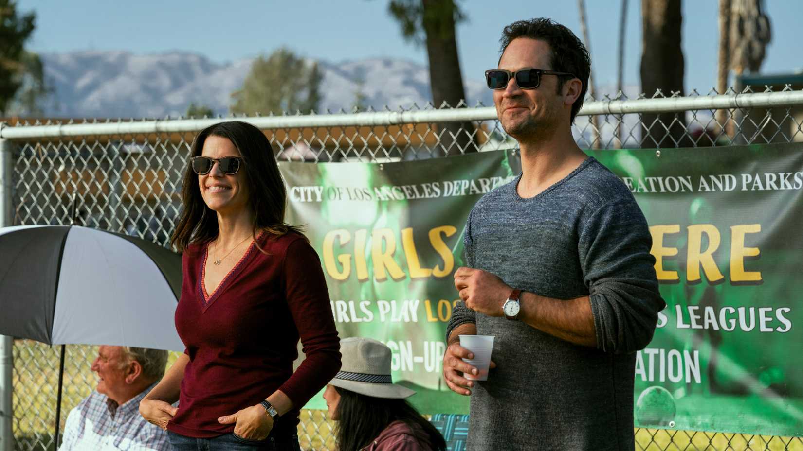 Manuel Garcia-Rulfo and Neve Campbell smiling in The Lincoln Lawyer