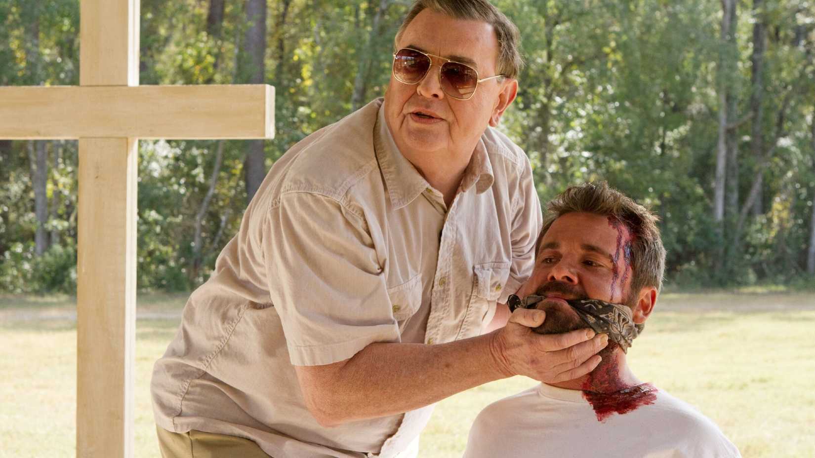 Padre segura um homem ensanguentado e amordaçado em O Sacramento