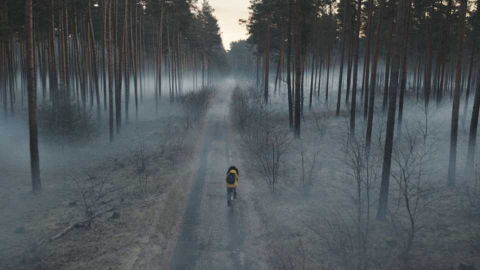 Martha cycling through a misty forest