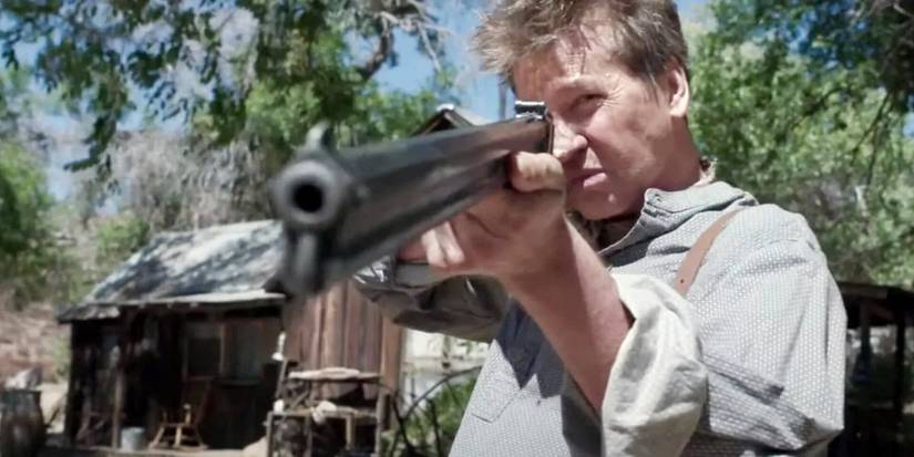 Val Kilmer apontando um rifle como CJ em A Soldier's Revenge