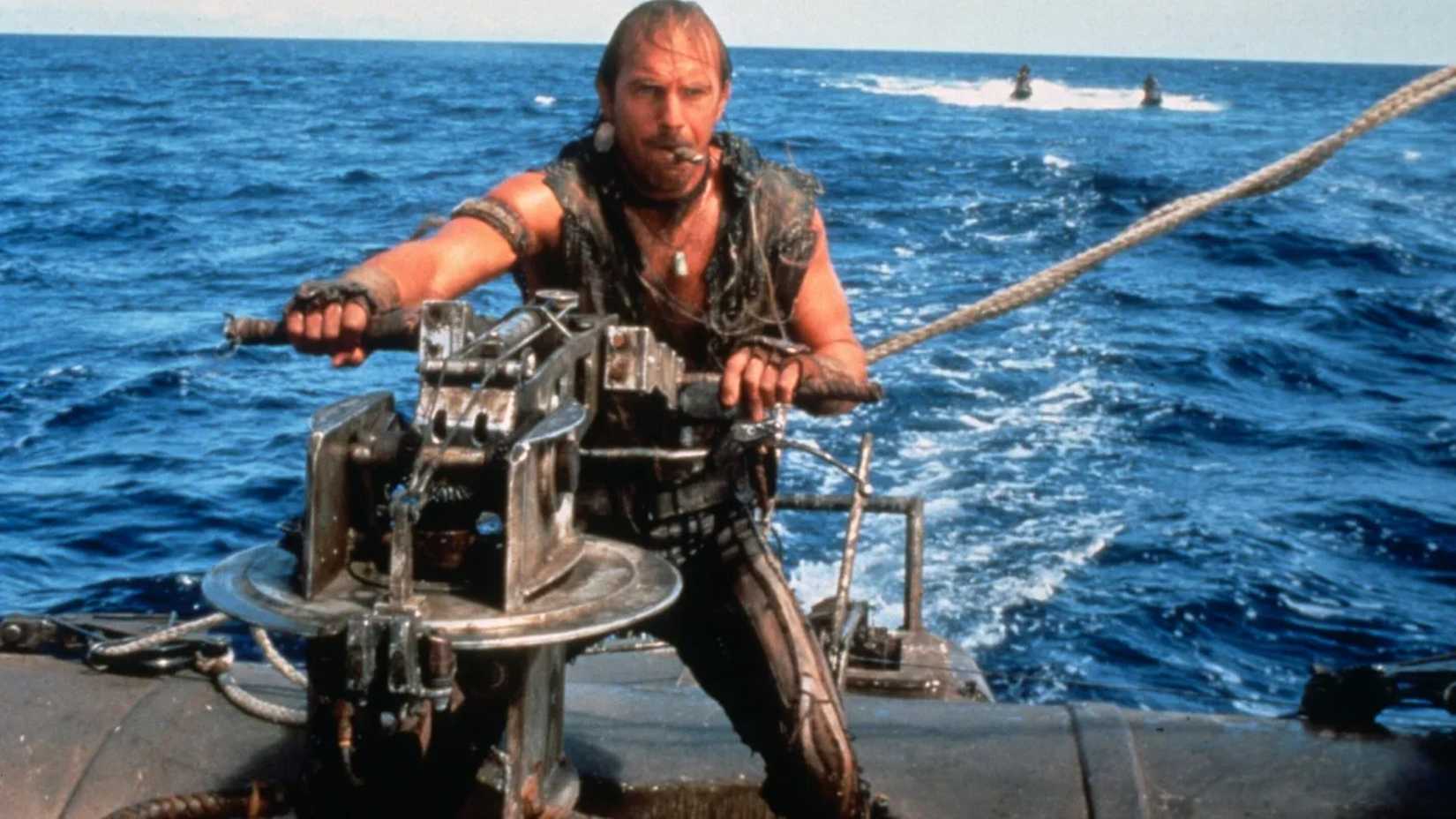 Kevin Costner pilota um barco em Waterworld: O Marinheiro das Trevas